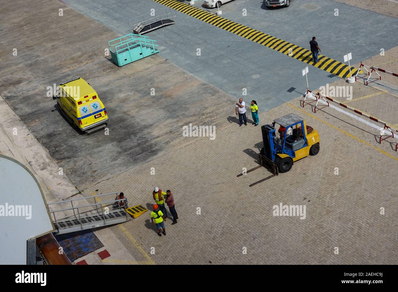 Aruba-11/4/19: porta i lavoratori portuali e la nave di crociera equipaggio lavorando duramente l'impostazione di una rampa per il trasporto di passeggeri su off la nave. Foto Stock