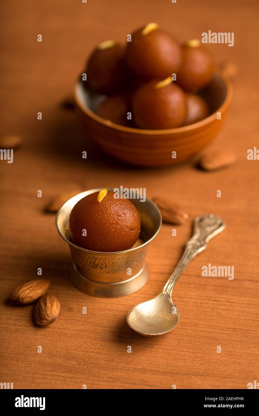 Gulab Jamun nella ciotola e rame antico ciotola con cucchiaio. Indian dessert o un piatto dolce. Foto Stock