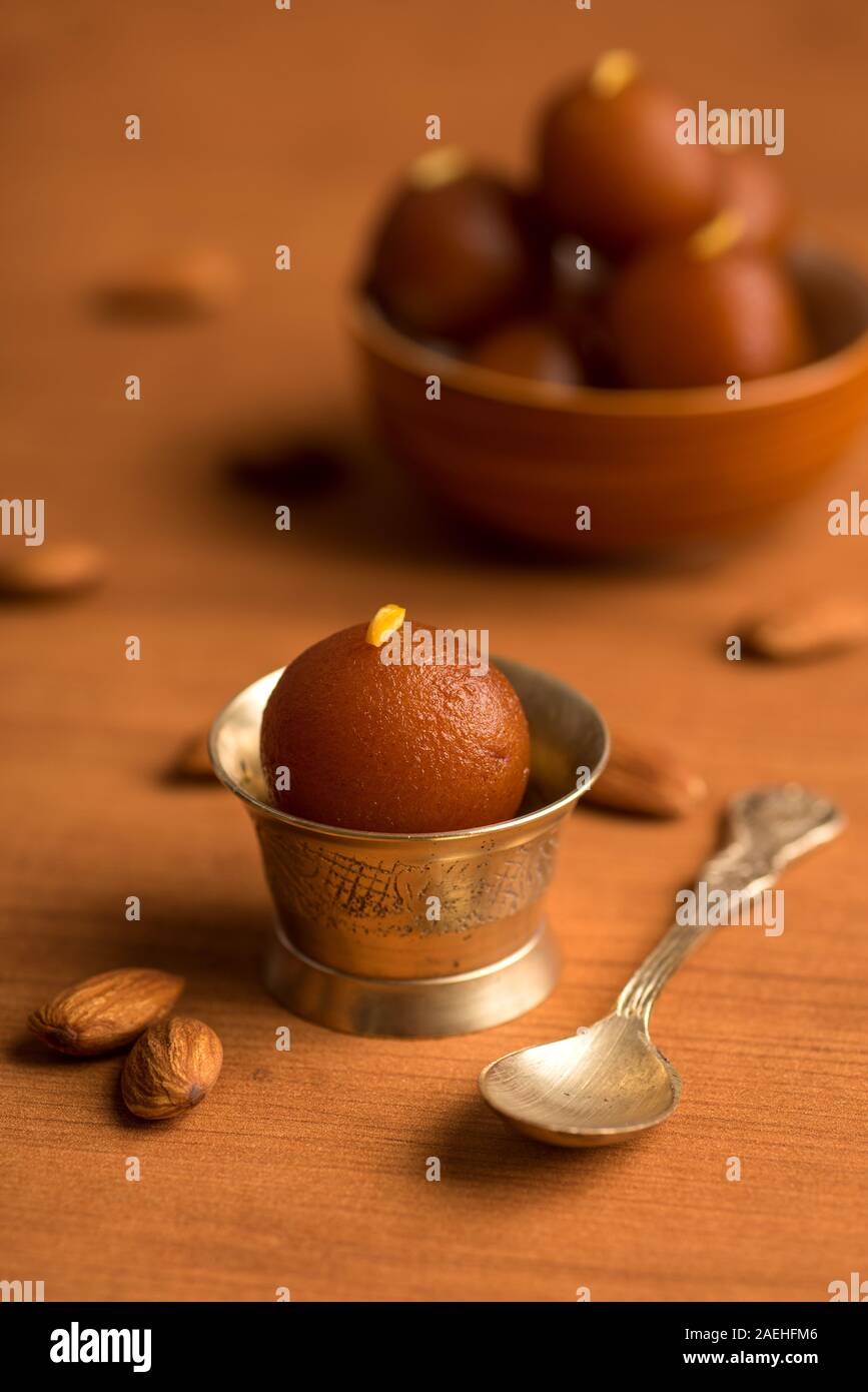 Gulab Jamun nella ciotola e rame antico ciotola con cucchiaio. Indian dessert o un piatto dolce. Foto Stock