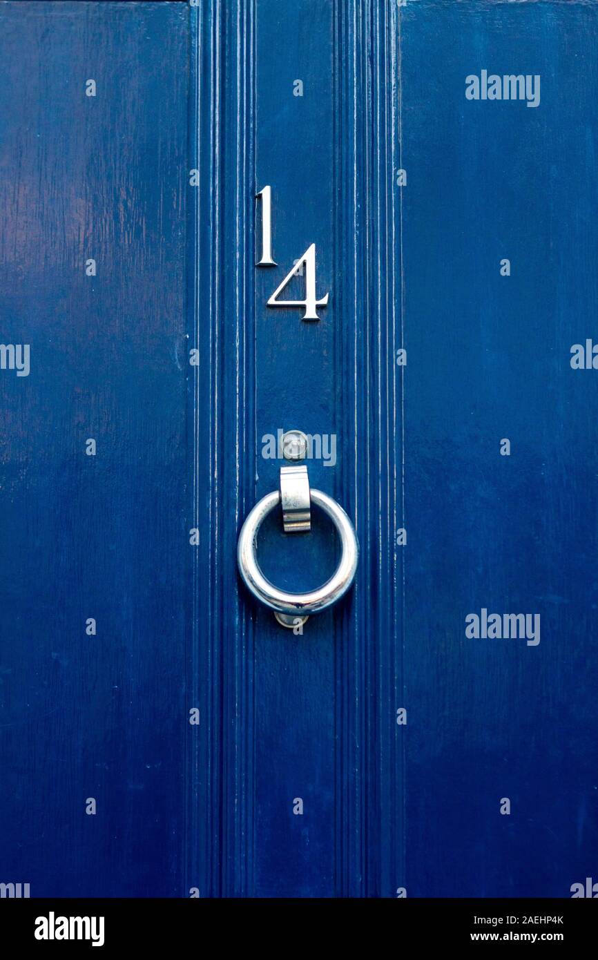 Il numero civico 14 su un blu in legno porta anteriore Foto stock - Alamy