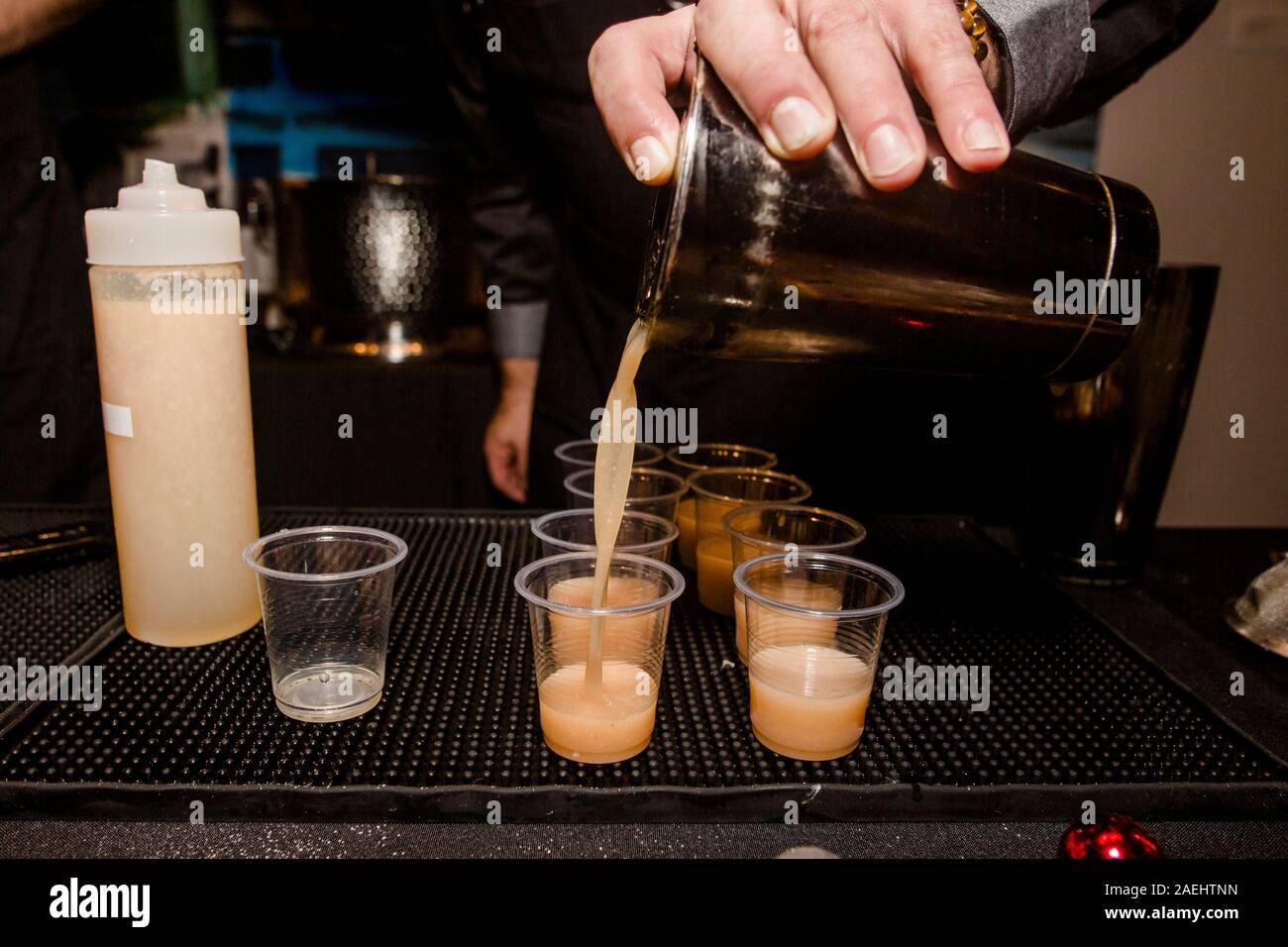 Close-up di barman mescita di bevande da shaker in bicchierini Foto Stock