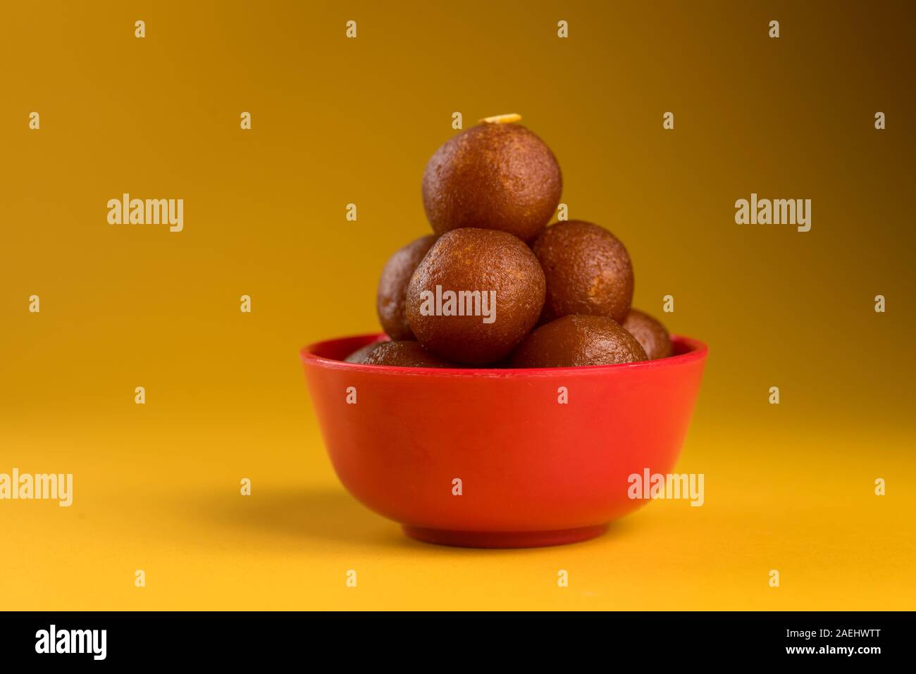 Indian dessert o un piatto dolce : Gulab Jamun nella ciotola su sfondo giallo. Foto Stock