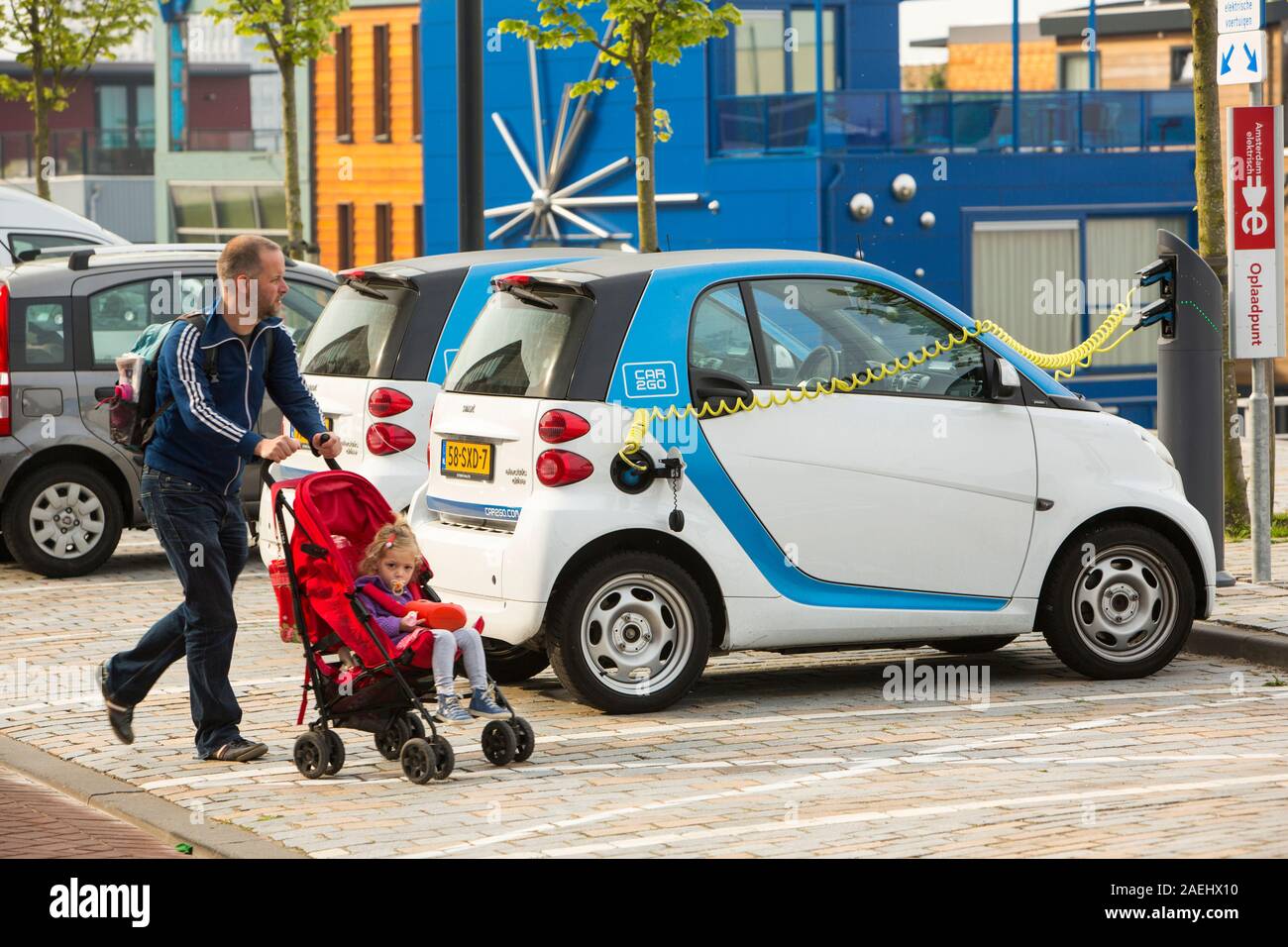 Una Smart auto auto elettrica in corrispondenza di una stazione di ricarica per auto elettriche a Ijburg, Amsterdam, Paesi Bassi, nella parte anteriore del case galleggianti. Foto Stock