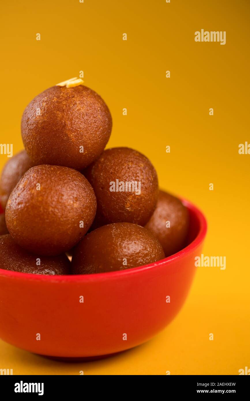 Indian dessert o un piatto dolce : Gulab Jamun nella ciotola su sfondo giallo. Foto Stock