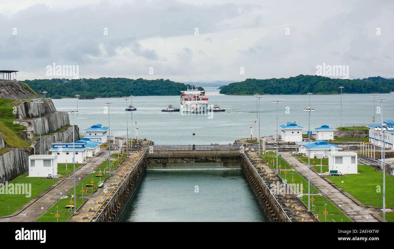 Nave container essendo la manovra da rimorchiatori in attesa di entrare le serrature Foto Stock