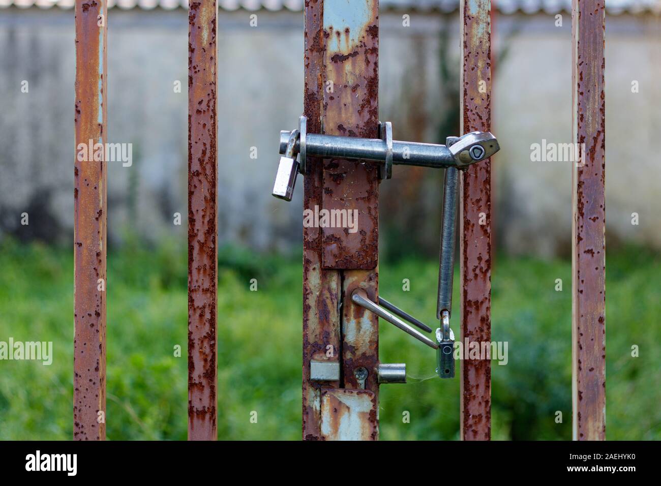 Coruna / Spagna - 08 dicembre 2019: Tripla lucchetti su un metallo arrugginito cancello Foto Stock