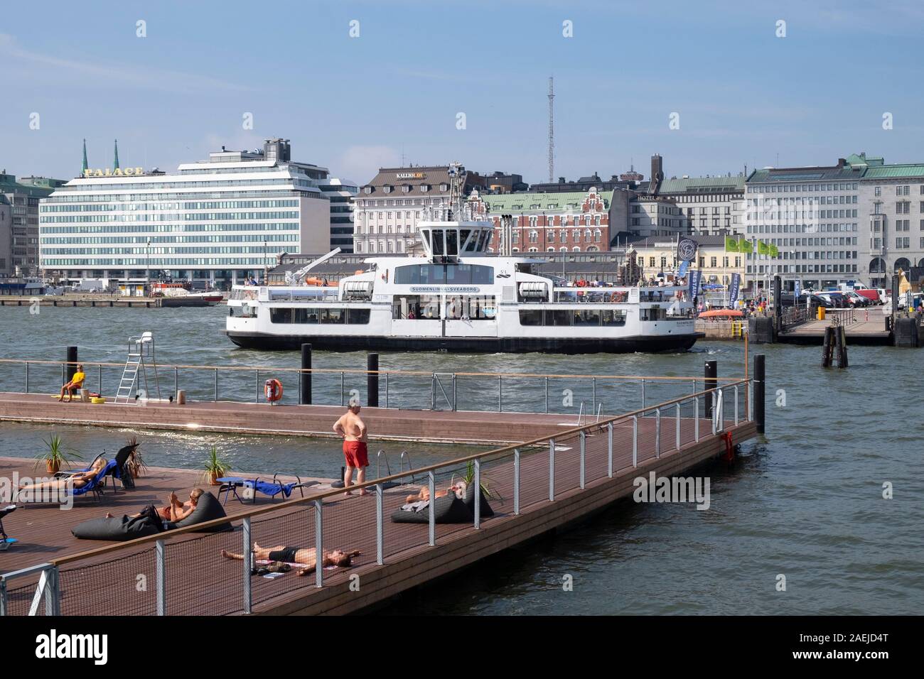 Vista in elevazione del popolo a prendere il sole a Allas mare Piscina vicino a sud del porto con il traghetto Suomenlinna e Palace Hotel in background, Helsinki, Finlandia, scansione Foto Stock