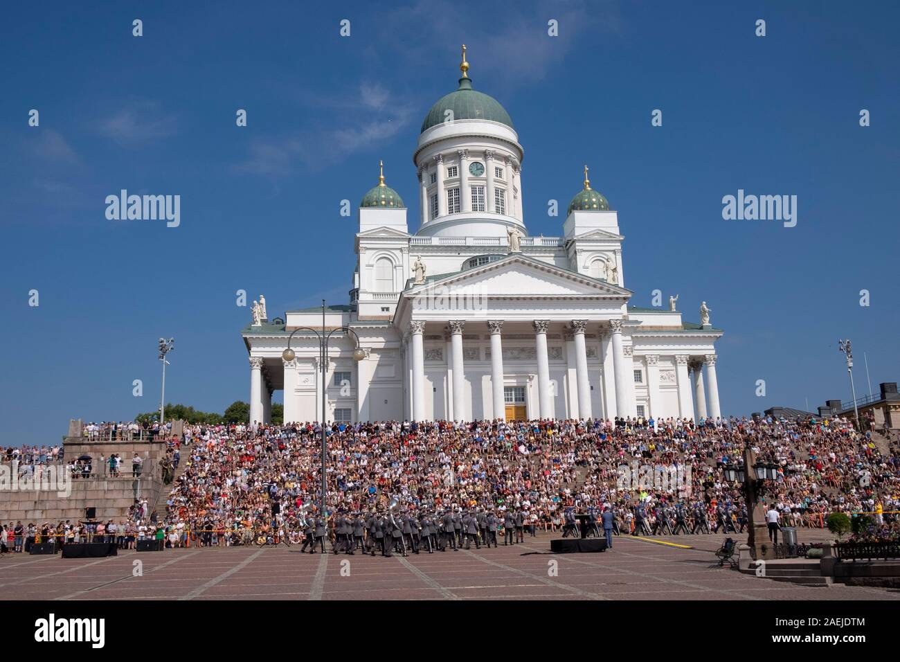 Vista su tutta la Piazza del Senato verso la banda militare e la gente seduta sui gradini della cattedrale di Helsinki, Helsinki, Finlandia e Scandinavia, Europa Foto Stock