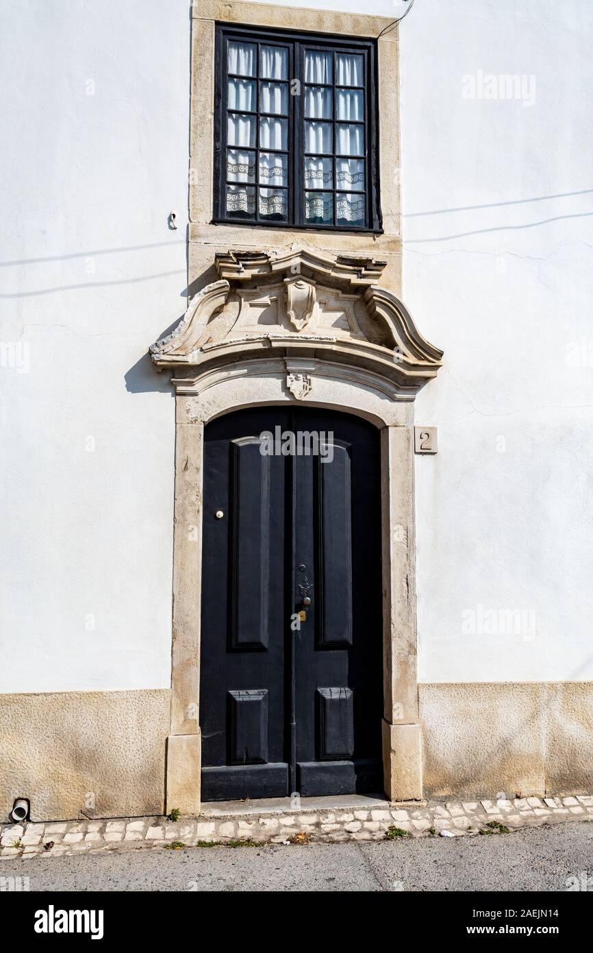 Dettaglio di un classico della porta e finestra sulla facciata di una antica casa residenziale in Tentugal, Coimbra, Portogallo Foto Stock
