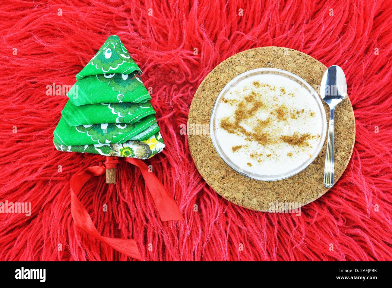 Greco tradizionale budino di riso, rizogalo e un tovagliolo piegato nella forma di un albero di Natale sul rosso capelli lunghi rug Foto Stock