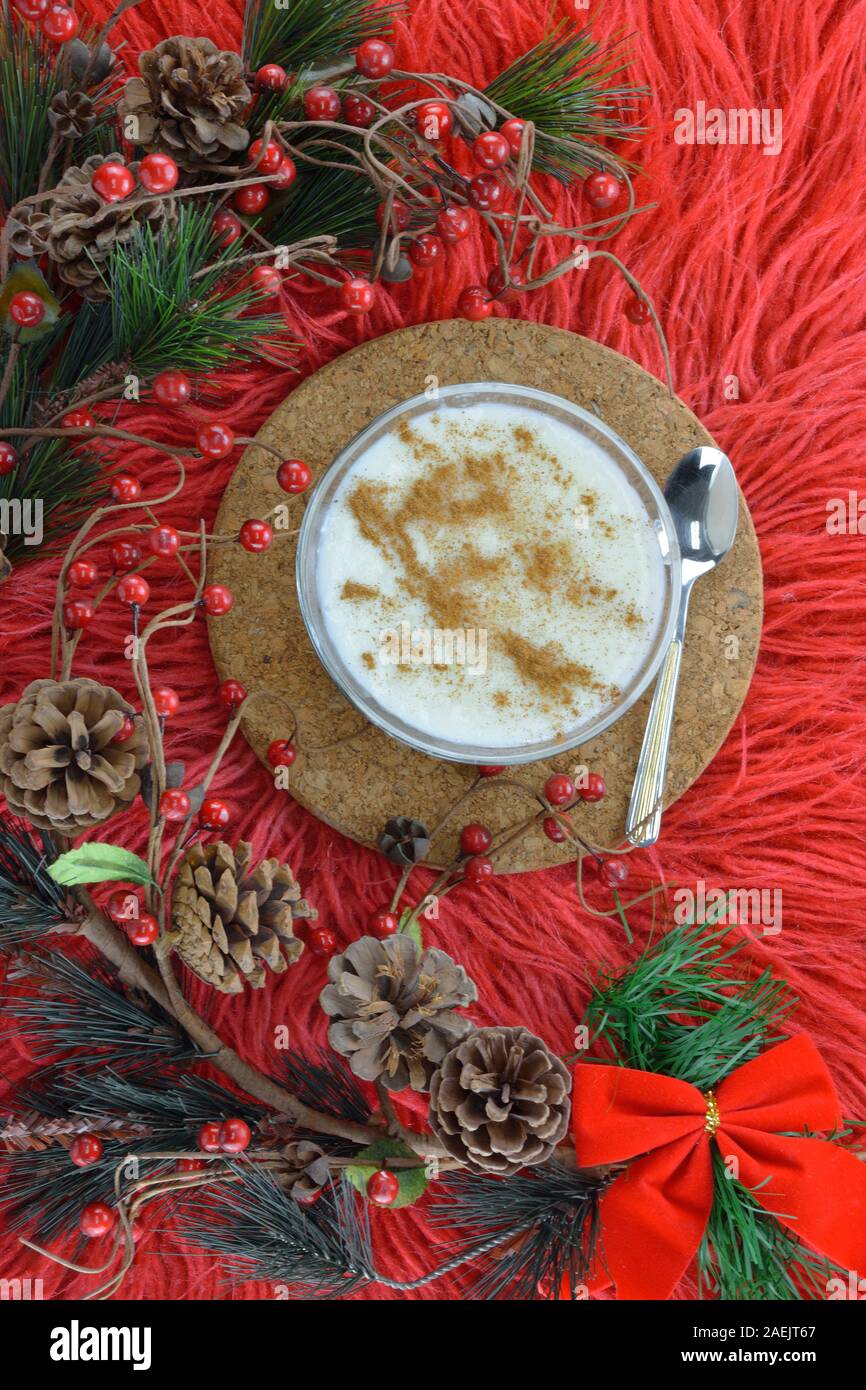 Budino di riso e artificiale rami sempreverdi su rosso lungo rug Foto Stock