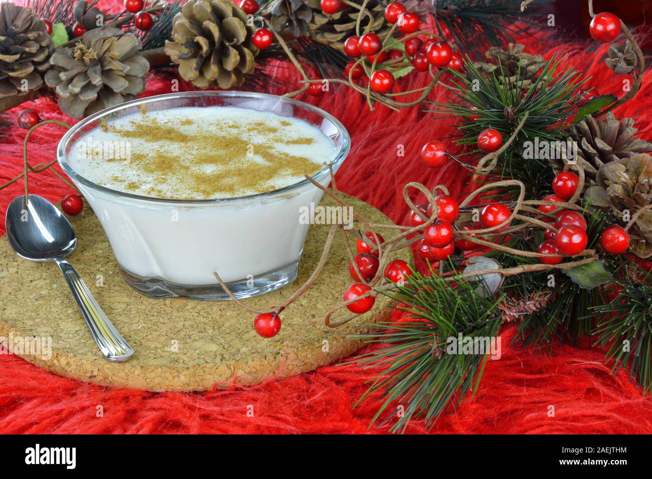 Budino di riso e artificiale rami sempreverdi su rosso lungo rug Foto Stock