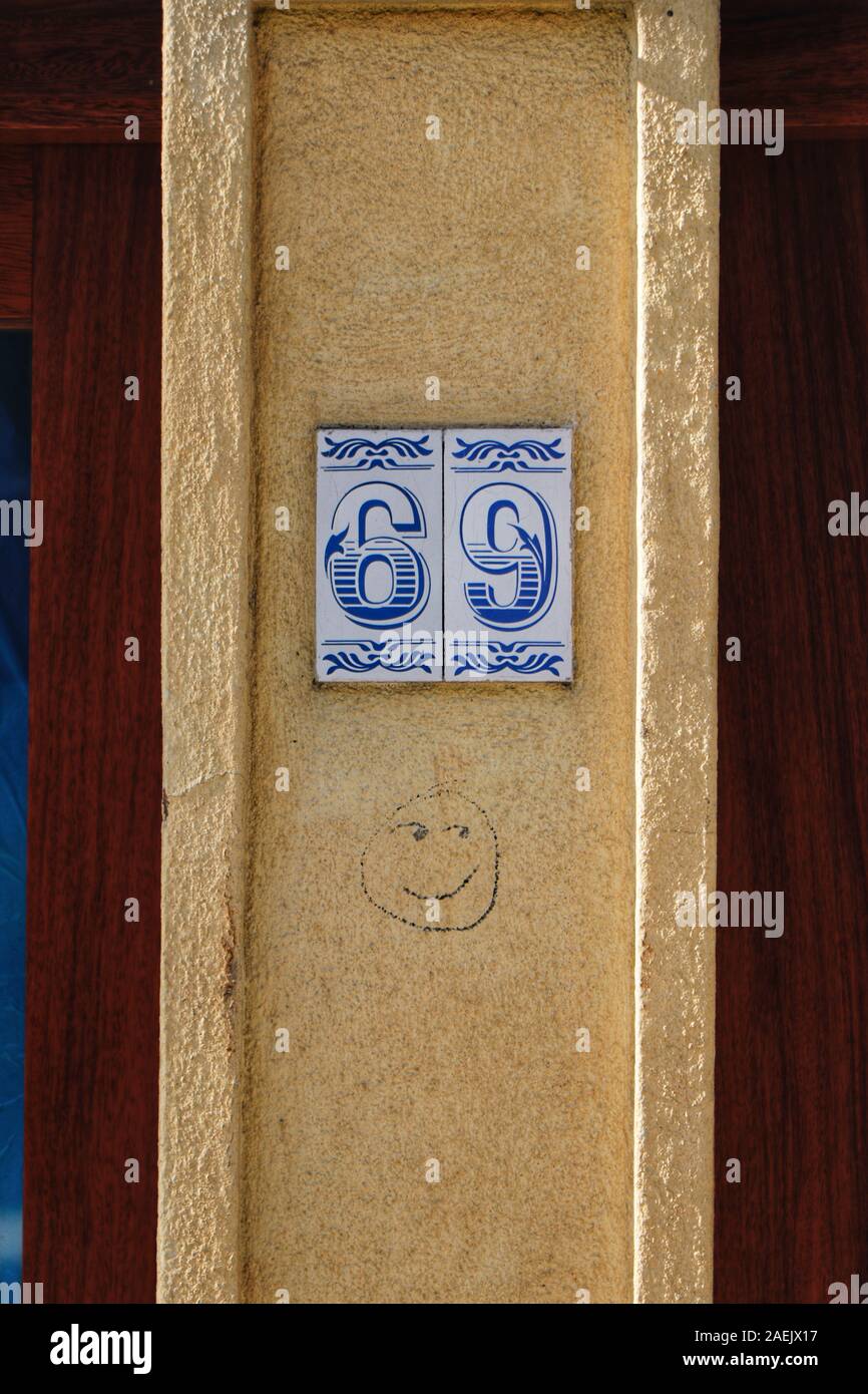 Numero civico 69 con cheeky graffiti Smiley face Foto Stock
