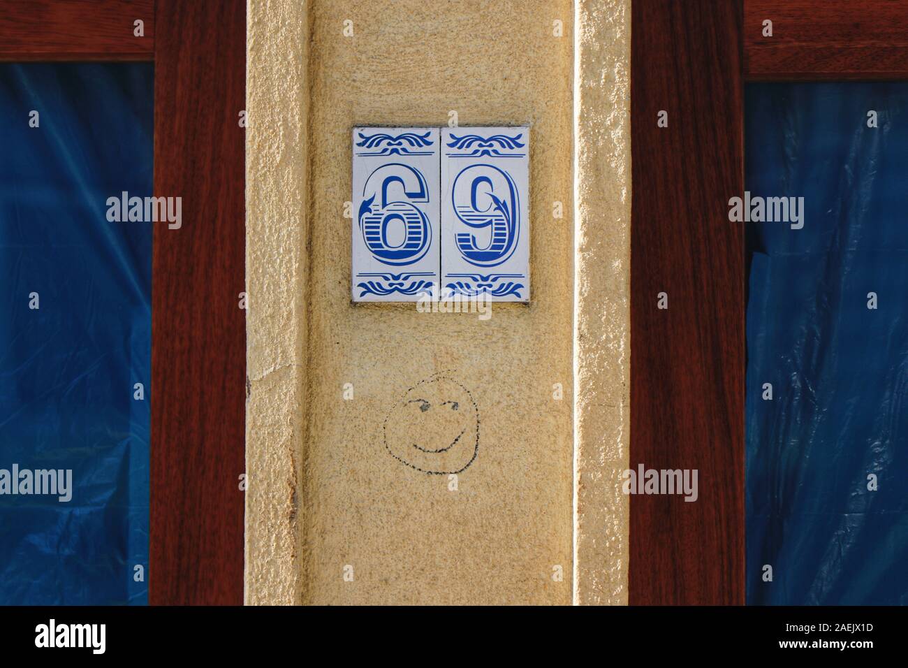 Numero civico 69 con cheeky graffiti Smiley face Foto Stock