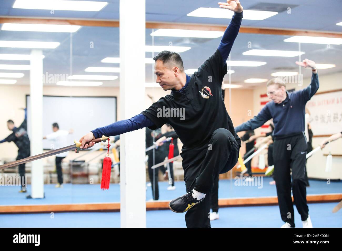 New York, Stati Uniti d'America. Xx Nov, 2019. Chen Sitan (anteriore) pratiche Tai Chi spada con gli studenti a Sitan Tai Chi e arti marziali, un arte marziale scuola in Syosset di New York, Stati Uniti, nov. 20, 2019. L'antica arte marziale cinese Tai Chi è divenuta sempre di più una forma di vita per molti newyorkesi, grazie agli sforzi compiuti dalla ex mondo di arte di Martial champion Chen Sitan e sua moglie Lin Xu.PER ANDARE CON 'Funzione: l'ex campione del mondo porta Tai Chi in Newyorkesi " vita " Credito: Wang Ying/Xinhua/Alamy Live News Foto Stock