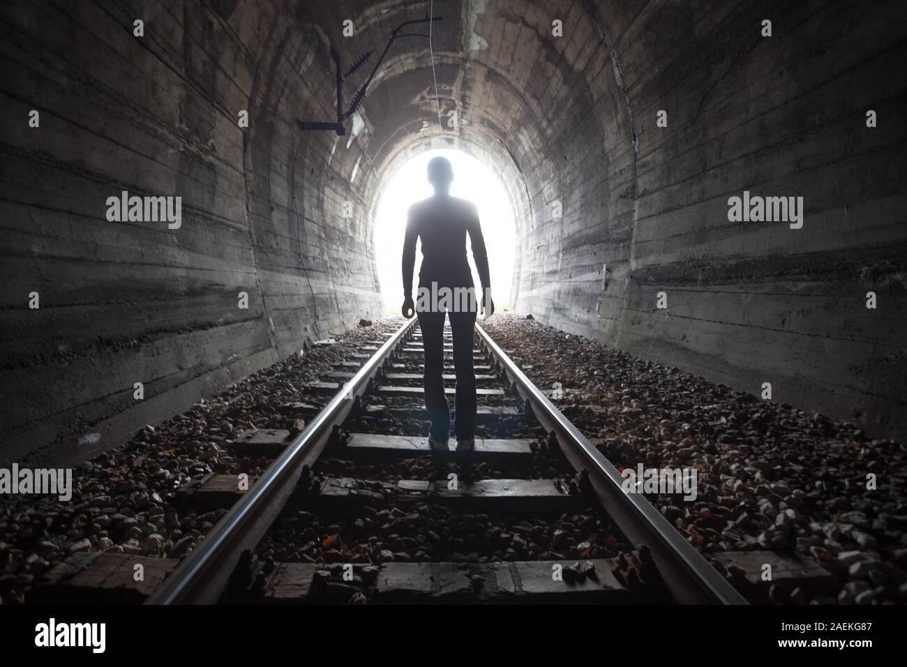 Uomo in un tunnel guardando verso la luce Foto Stock
