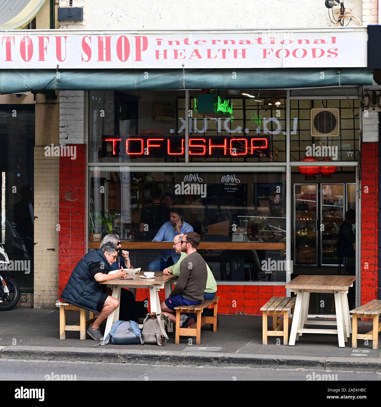Scena di strada, di un gruppo di persone mangiare sulla strada, Bridge Road, Richmond, Victoria, Australia. Foto Stock