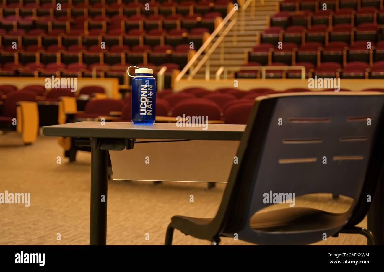 Storrs, CT, Stati Uniti d'America. Ott 2019. Svuotare universty lecture hall con una perdita di acqua in bottiglia sulla tavola degli educatori. Foto Stock