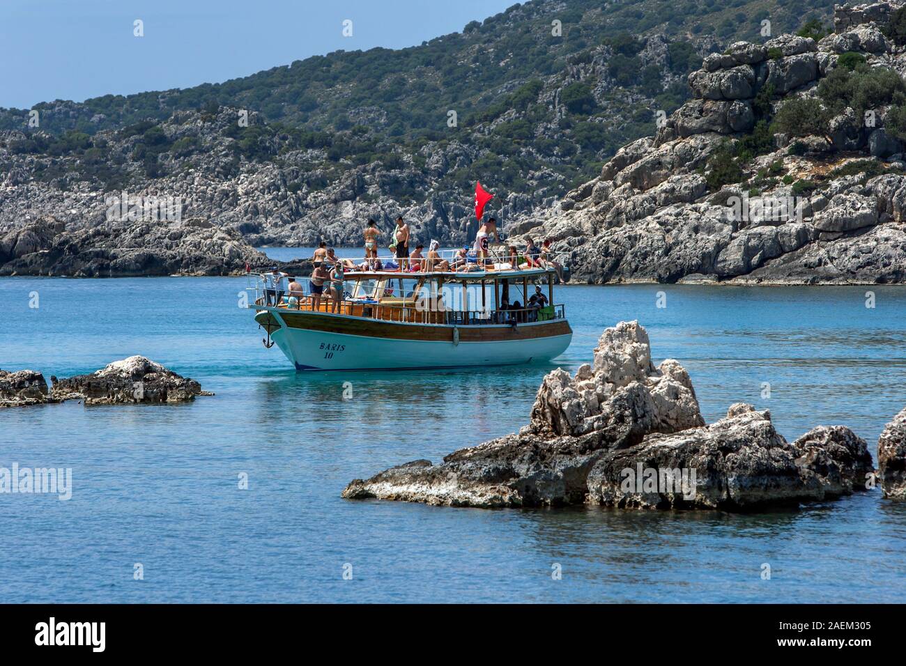 I turisti a bordo di un battello da crociera godetevi la primavera tempo caldo mentre esplorare adiacente alla Città Sommersa di Simena vicino Kekova island in Turchia. Foto Stock