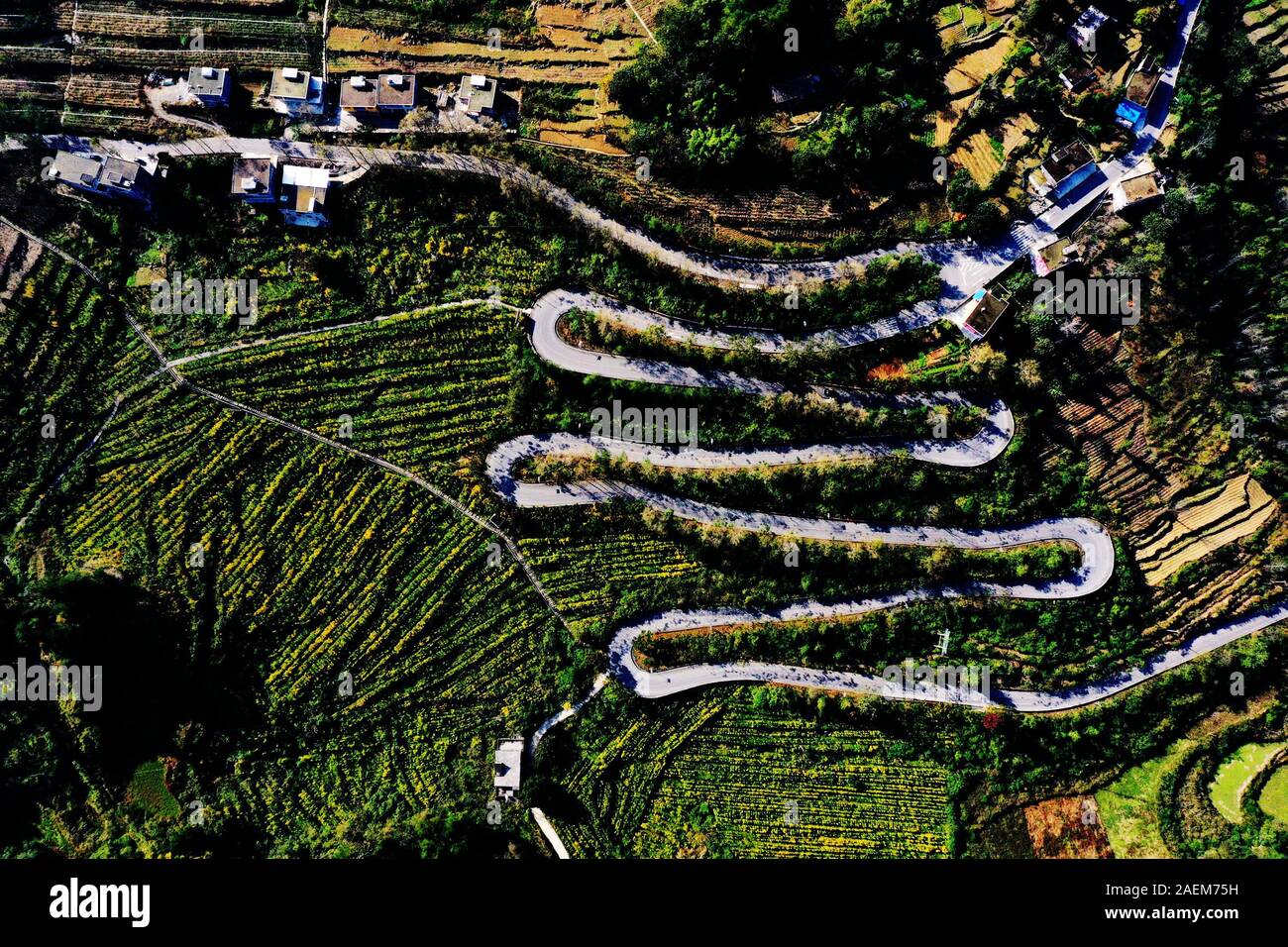 Una veduta aerea di una autostrada a zig-zag di collegamento remoti e poveri villaggi individuazione tra le montagne al mondo esterno in città Shijia, distric Qianjiang Foto Stock