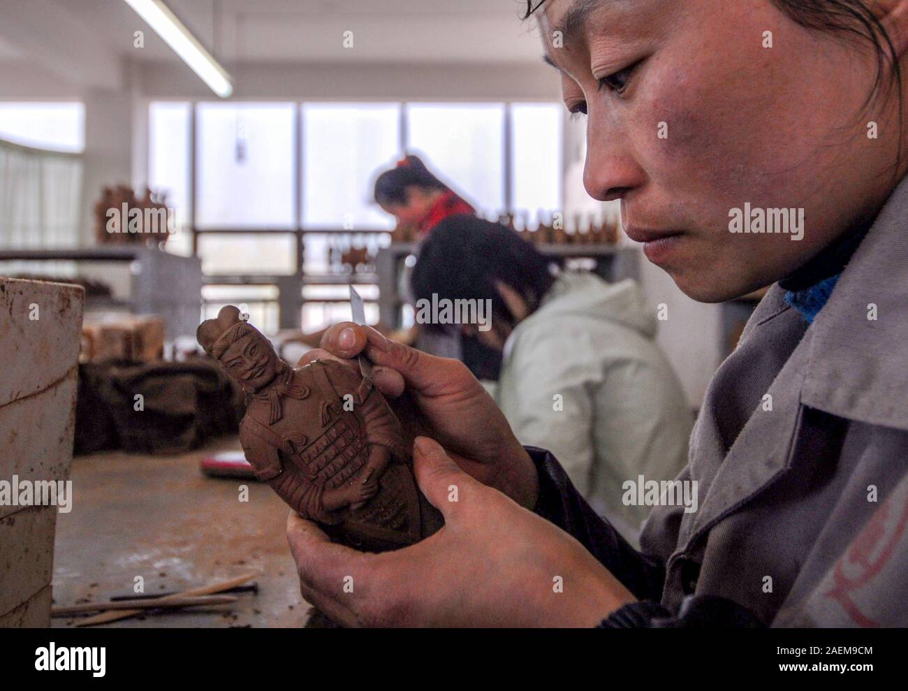 Un abitante locale in i Guerrieri di Terracotta borgo fa un Guerriero di terracotta a Xi'an City, a nord-ovest della Cina di provincia di Shaanxi, 8 novembre 2019. Foto Stock