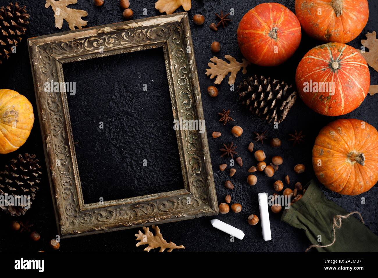 Telaio di autunno di zucche, foglie di albero, le nocciole su un nero tessiturali sfondo. Matite colorate per il disegno. In autunno, caduta, concetto di ringraziamento. Piatto, laici per Foto Stock