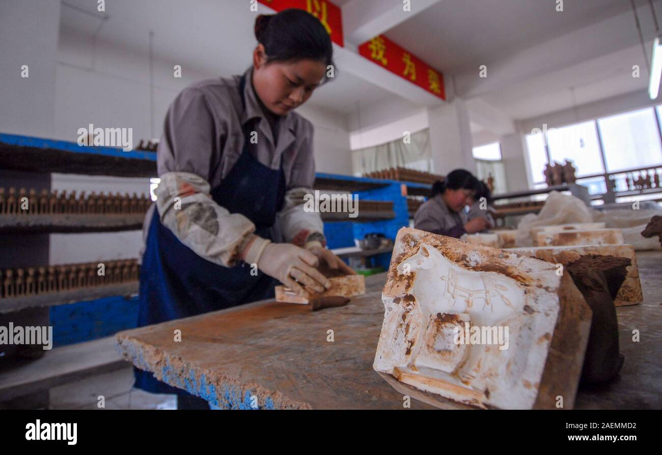 Un abitante locale in i Guerrieri di Terracotta borgo fa un Guerriero di terracotta a Xi'an City, a nord-ovest della Cina di provincia di Shaanxi, 8 novembre 2019. Foto Stock