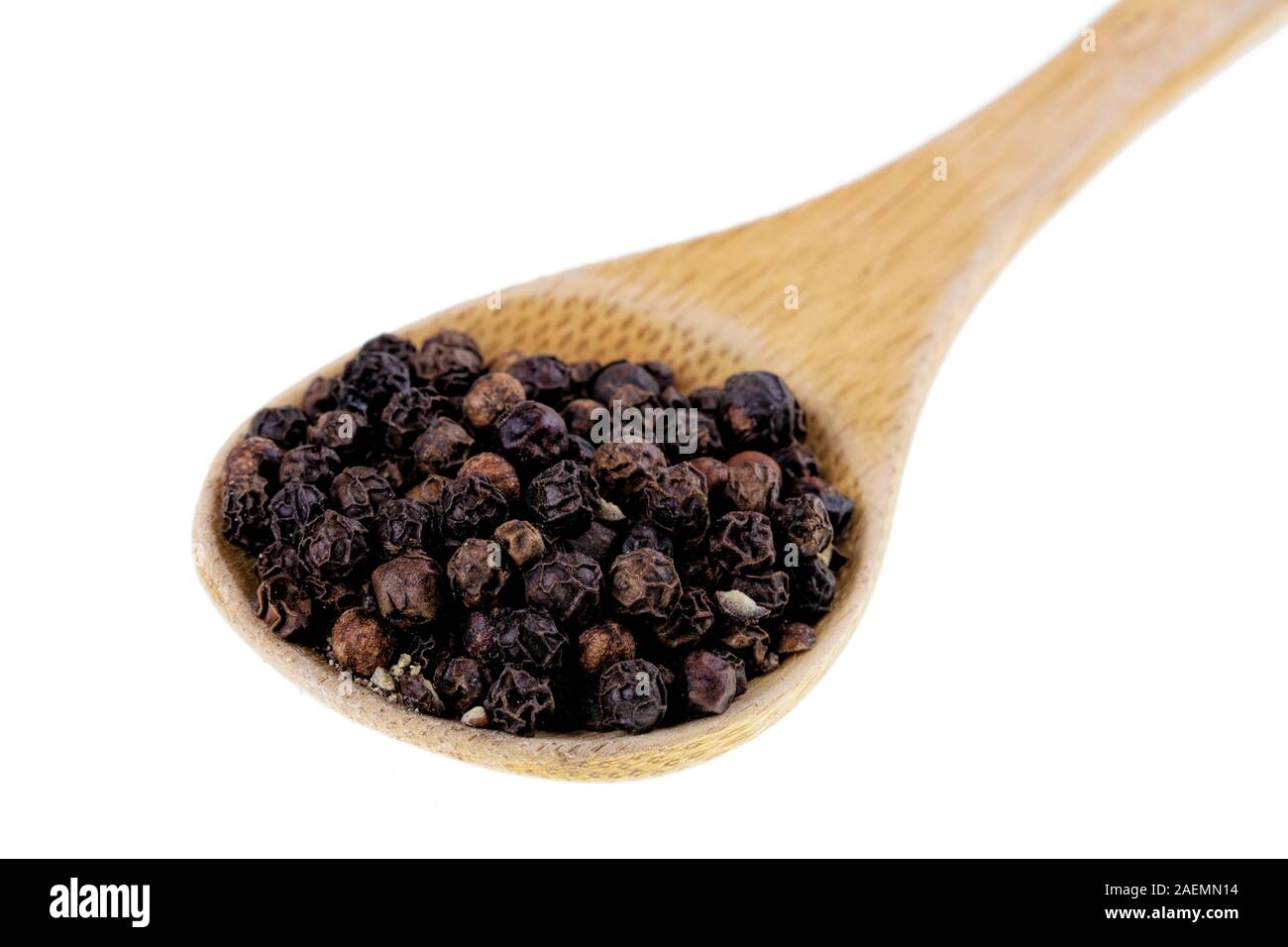 Cucchiaio di legno pieno di pepe nero in grani isolati su sfondo bianco Foto Stock