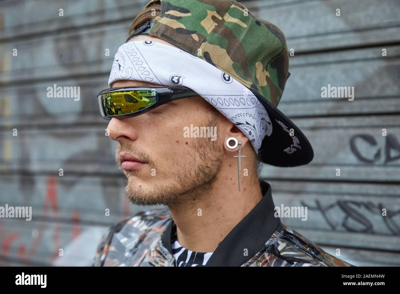 Milano, Italia - 22 settembre 2019: l'uomo con specchio verde occhiali da sole e cappello di mimetizzazione prima Boss fashion show, la Settimana della Moda Milanese street style Foto Stock
