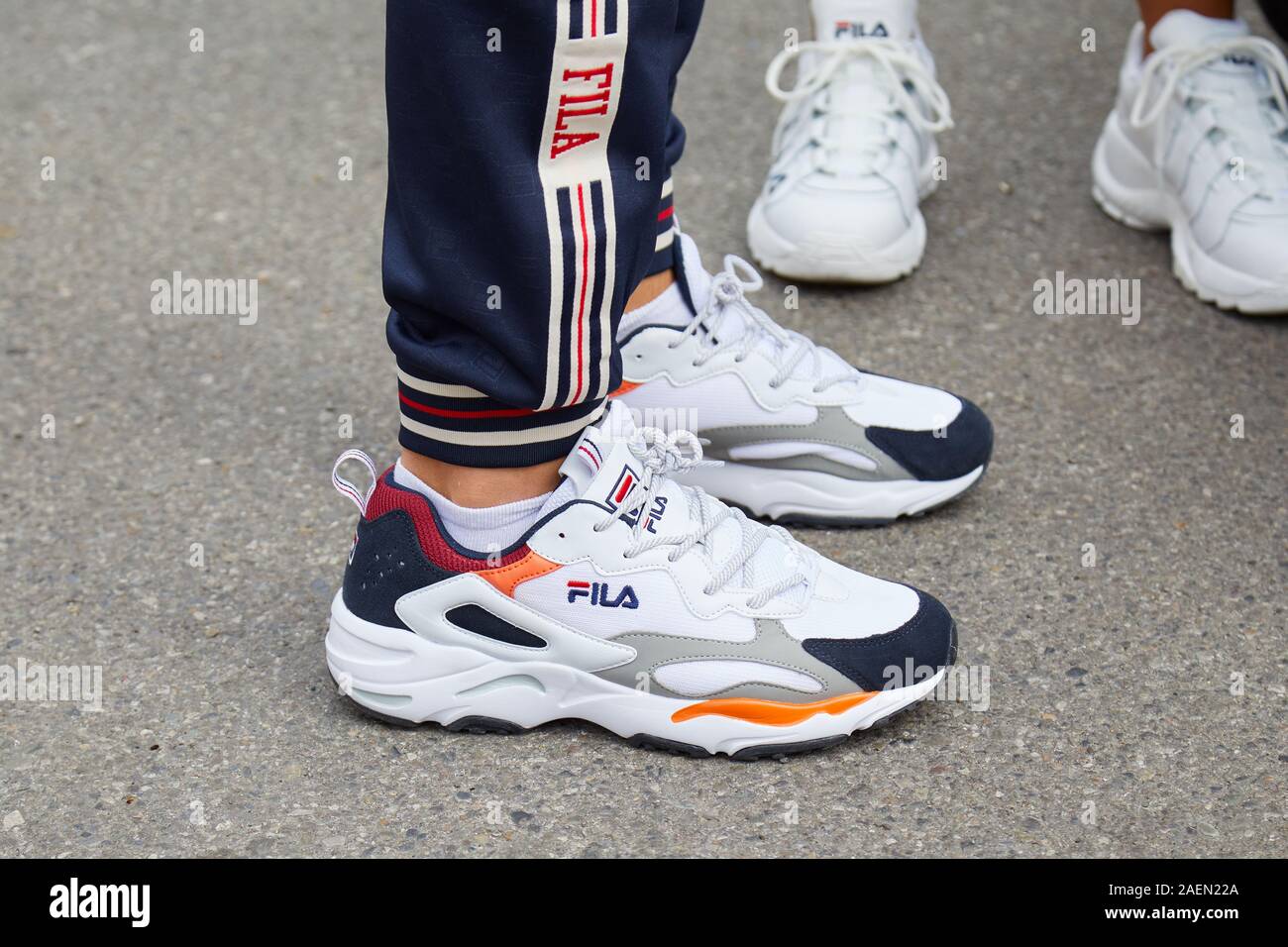 Milano, Italia - 22 settembre 2019: l'uomo con il bianco, arancio e blu Fila sneakers prima fila fashion show, la Settimana della Moda Milanese street style Foto Stock