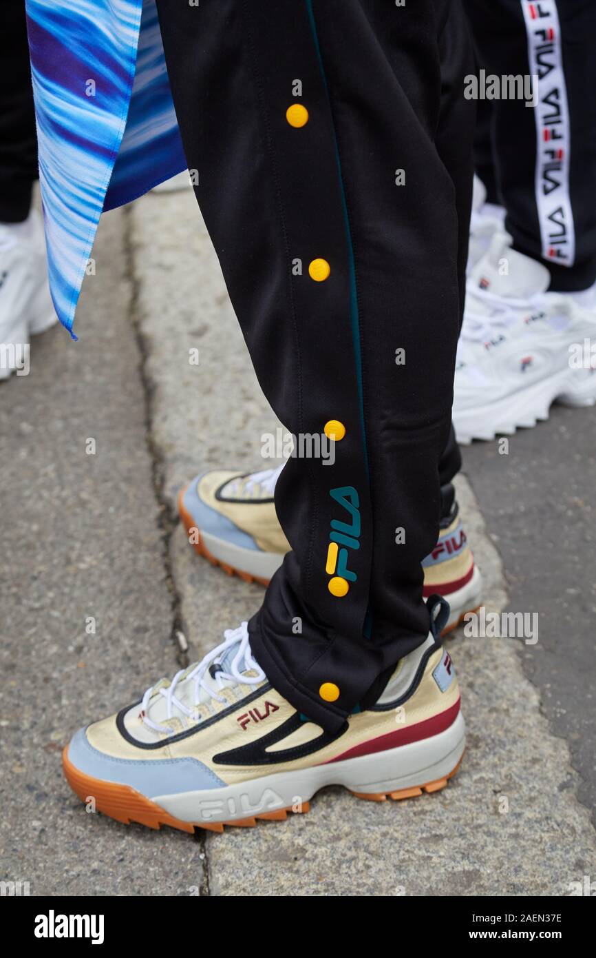 Milano, Italia - 22 settembre 2019: l'uomo con fila sneakers e black suit pantaloni prima fila fashion show, la Settimana della Moda Milanese street style Foto Stock