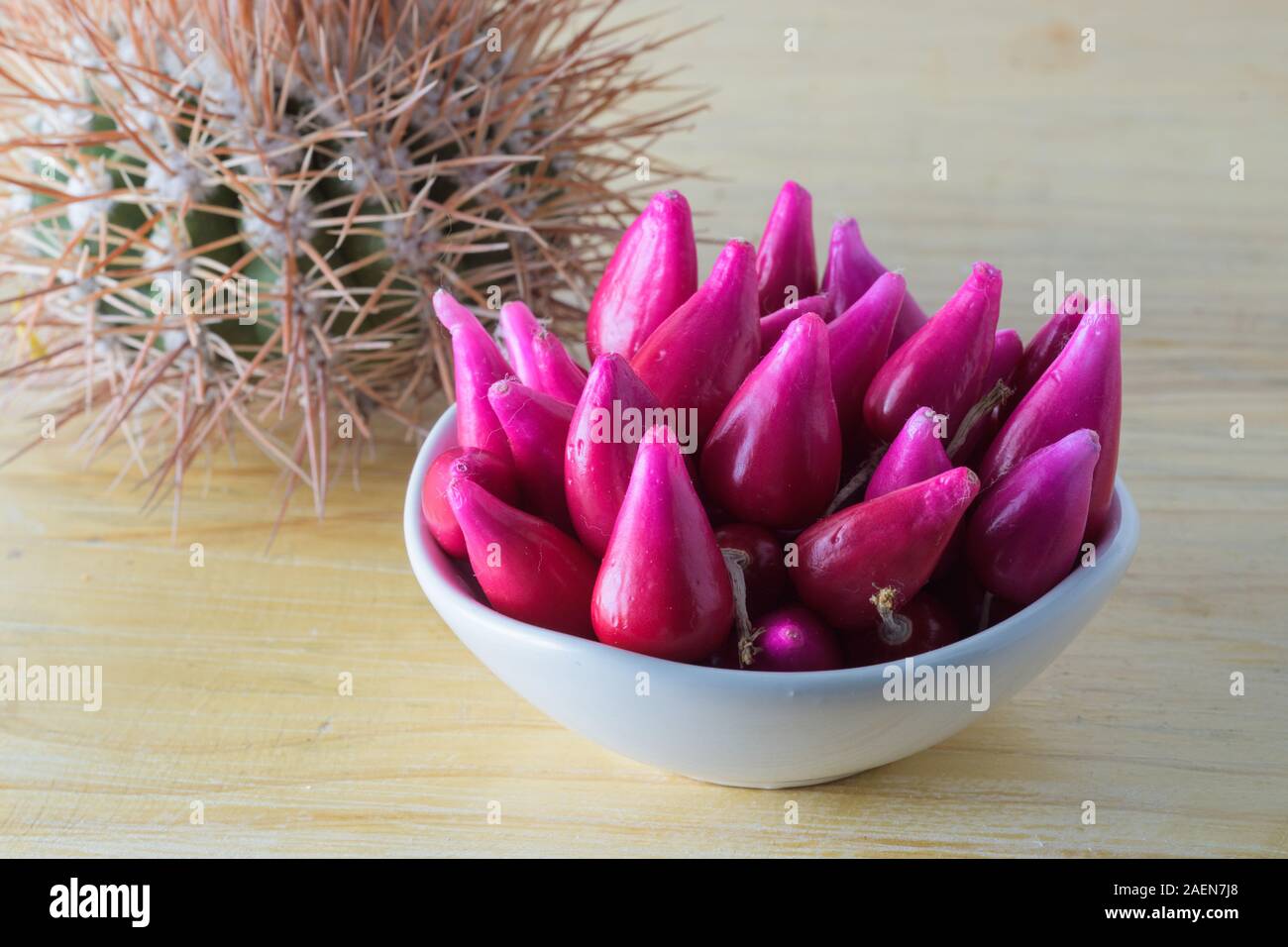Gruppo di frutta tropicale di Pitiguey in ciotola bianca su tavola di legno con Cactus. Foto Stock