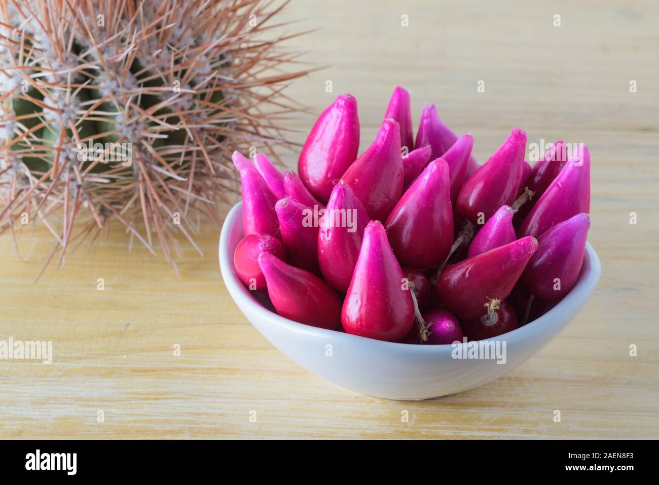 Gruppo di frutta di Pitiguey in ciotola bianca su tavola di legno con Cactus. Foto Stock