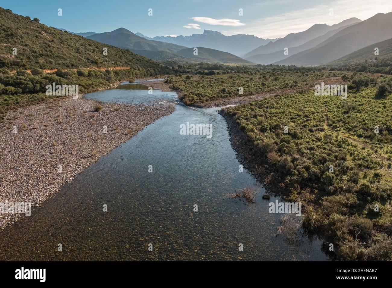 Le acque cristalline del fiume di fango vicino a Galeria in Corsica con la neve montagna ricoperte di Paglia Orba a distanza Foto Stock