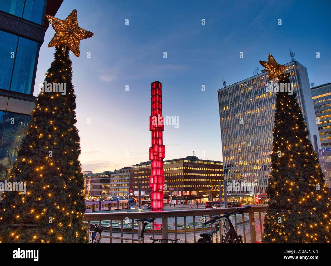 Obelisco di vetro illuminato in rosso e gli alberi di Natale, Sergels Torg, Stoccolma, Svezia Foto Stock