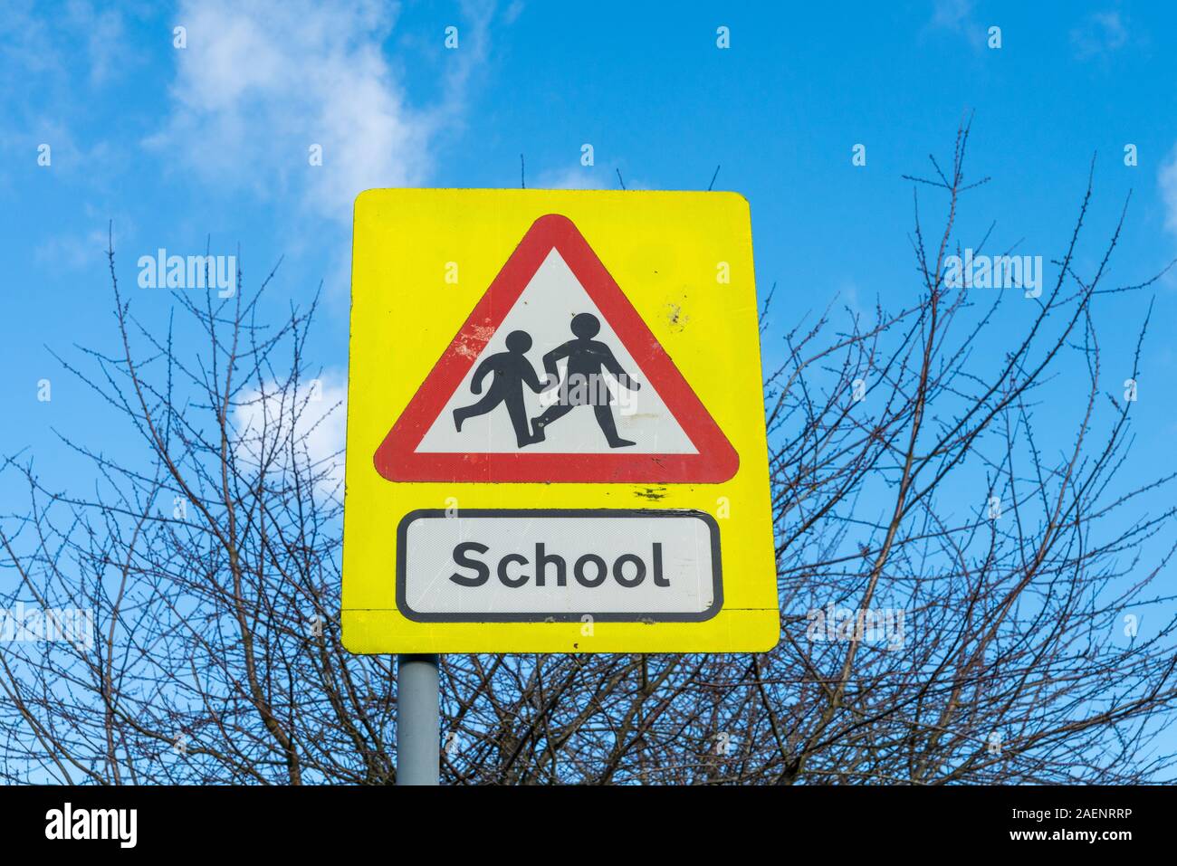 Un triangolo rosso cartello stradale attenzione dei bambini in età scolare Foto Stock