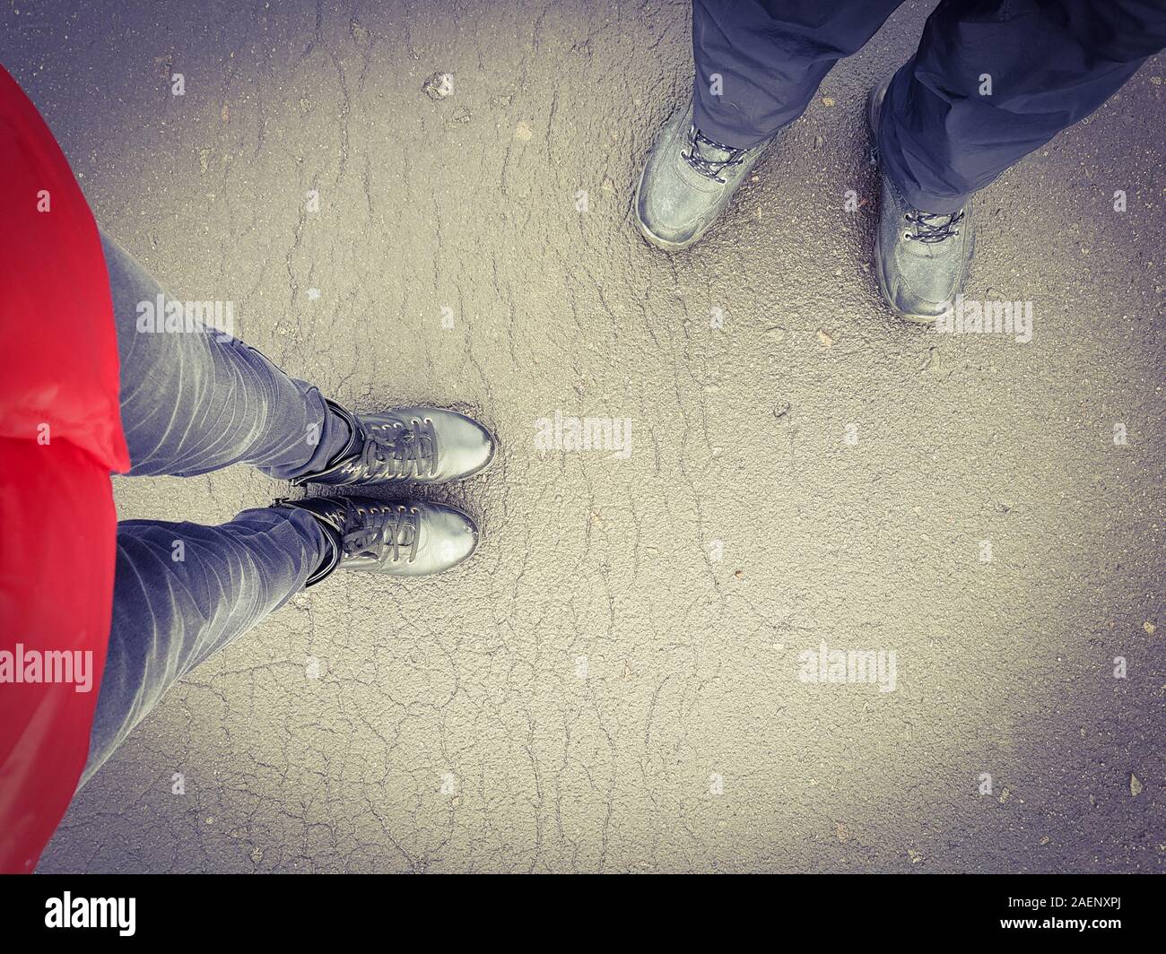 Due persone di un ragazzo e una ragazza sono in piedi sulla strada in stivali in pelle. Vista da sopra. Foto Stock