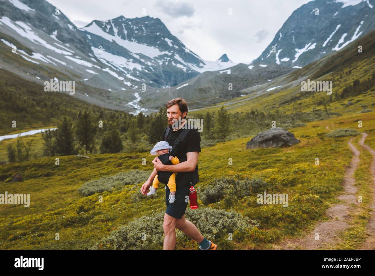 Padre escursionismo con baby carrier di viaggio lo stile di vita della famiglia avventura vacanze con bambini in montagna outdoor in Norvegia Foto Stock