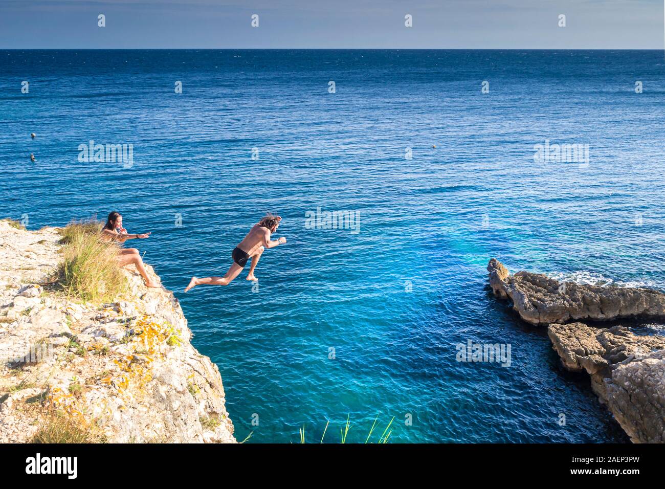 Croazia, Istria, Pola, Cape Kamenjak, uomo saltare da una scogliera Foto Stock