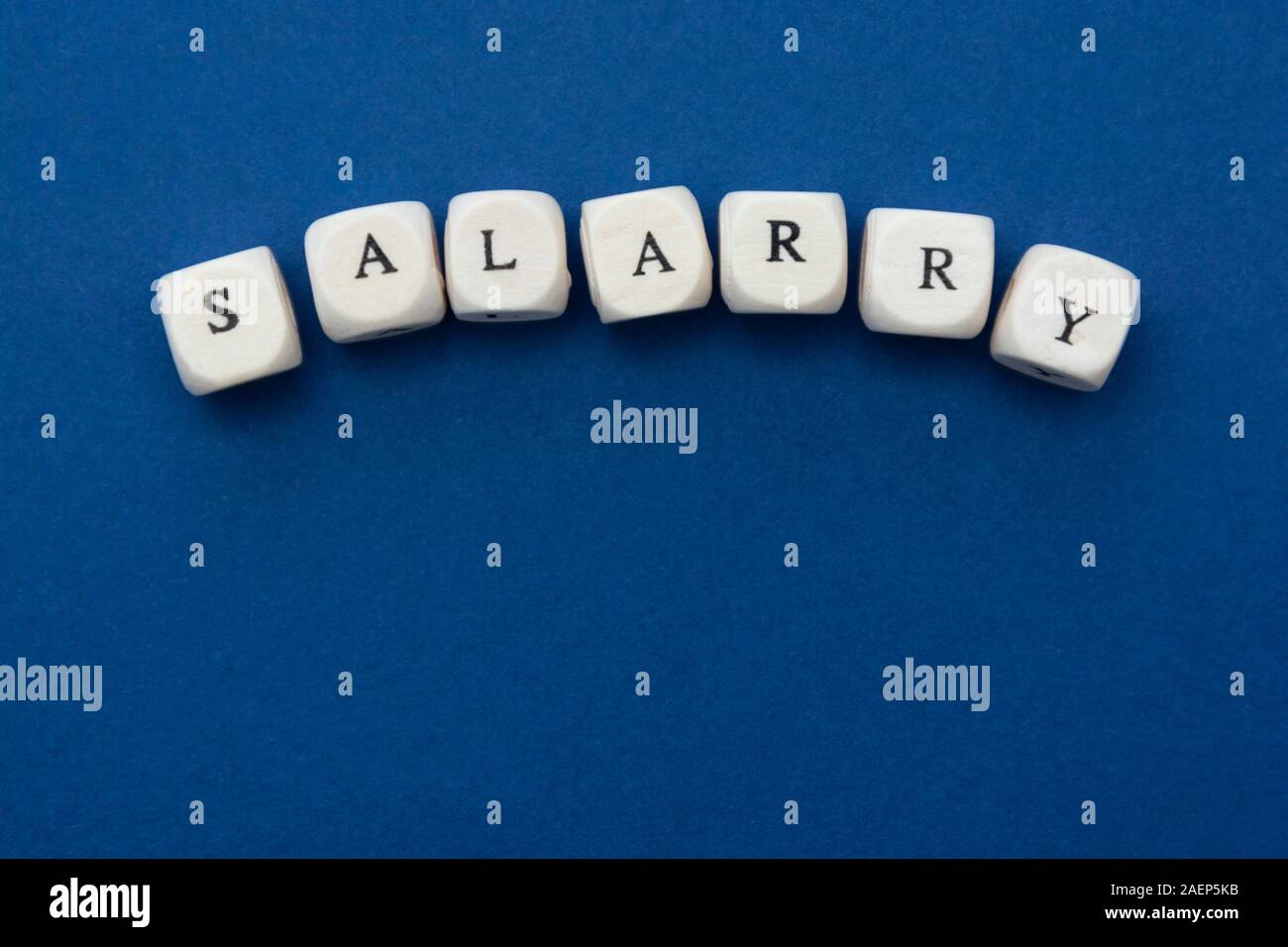 Parola di stipendio su blocchi su sfondo blu con una copia dello spazio. Concetto di finanza. Foto Stock