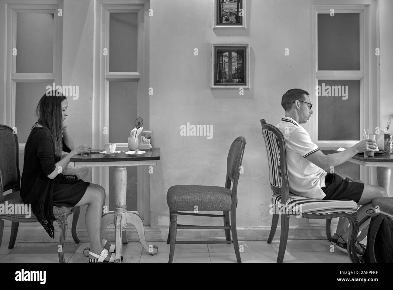 Concetto di single. Due persone singole in un ristorante seduto da solo. Sconosciuti Foto Stock