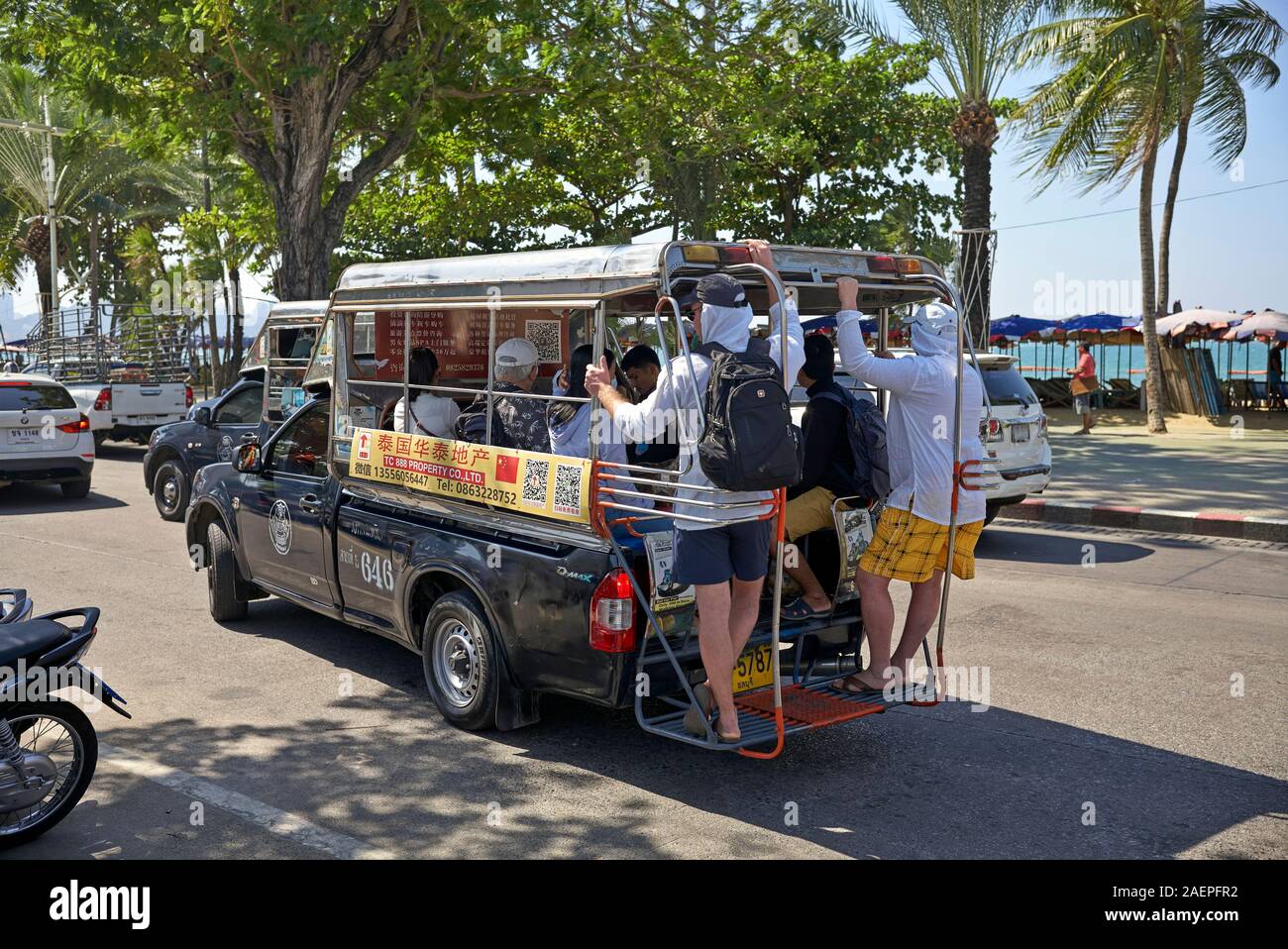 Songthaew Thailandia trasporti completamente caricato con persone a cavallo sulla parte posteriore della piattaforma del piede Foto Stock