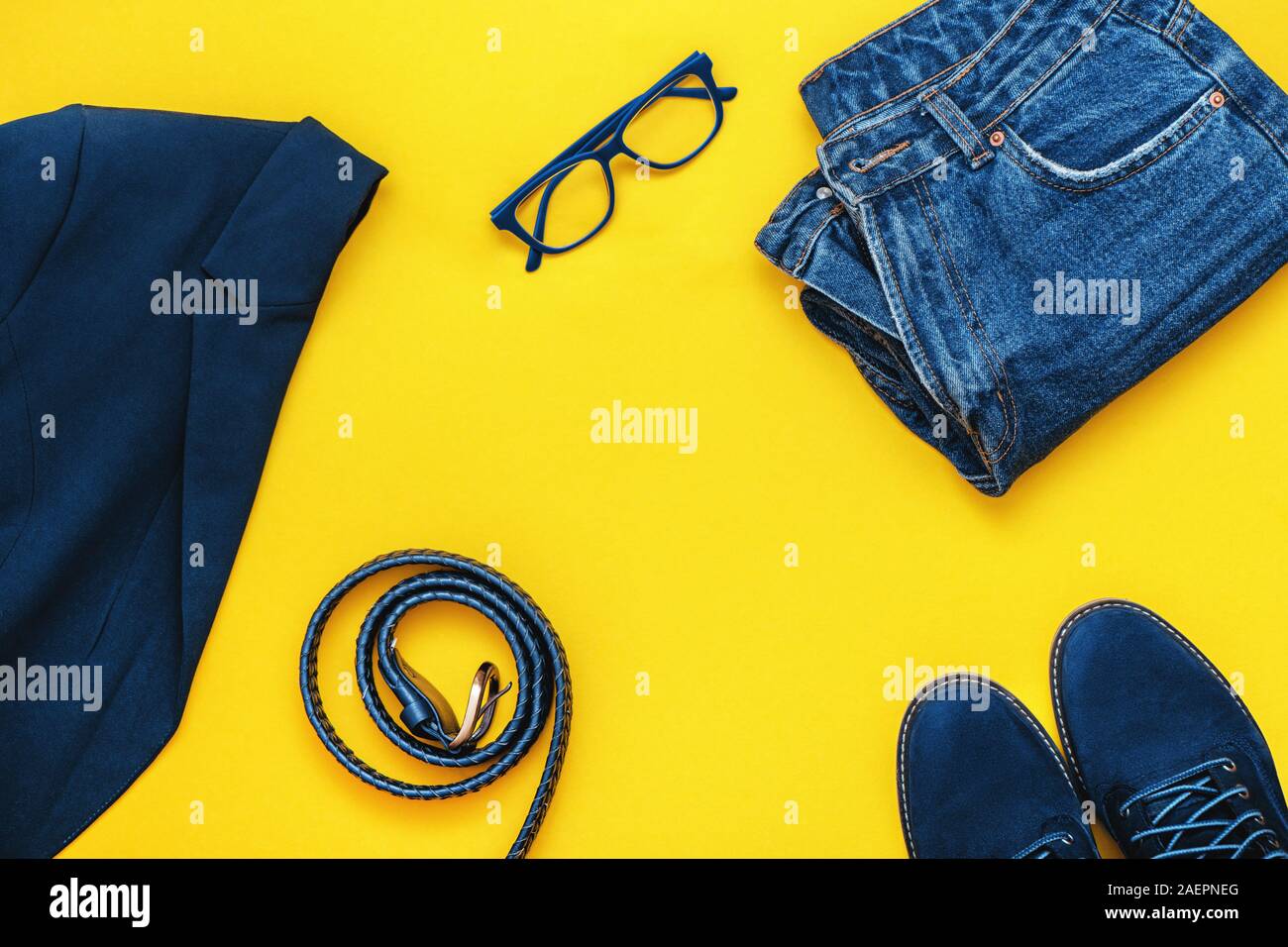 Vista superiore della donna abbigliamento casual impostato nel classico tono blu su sfondo giallo. Foto Stock