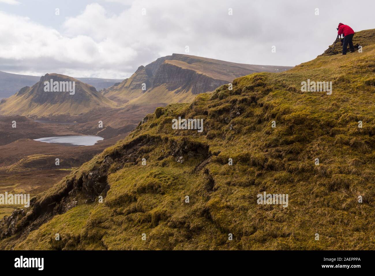 Fotografo con treppiede per scattare delle foto del paesaggio meraviglioso al Quiraing, Isola di Skye in Scozia, nel Regno Unito nel mese di marzo Foto Stock