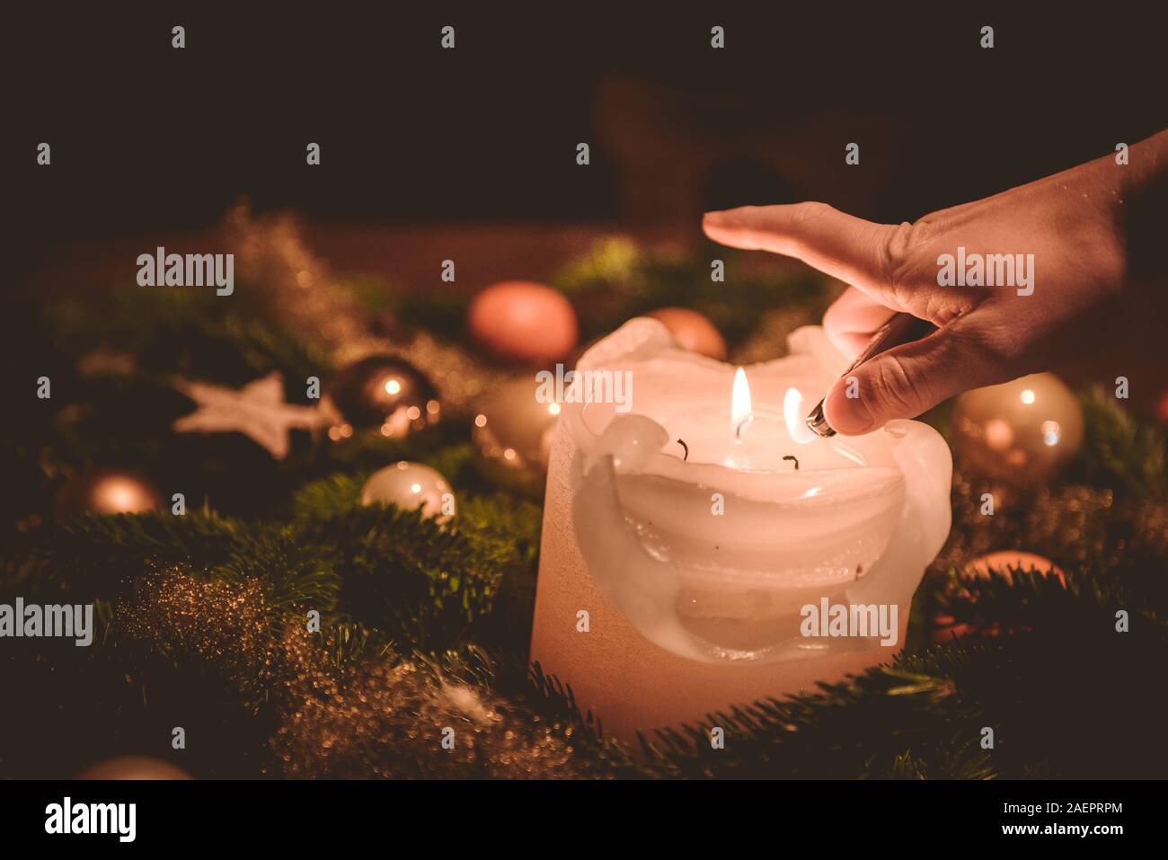 Illuminazione della candela sulla corona di Avvento durante il tempo di Natale Foto Stock