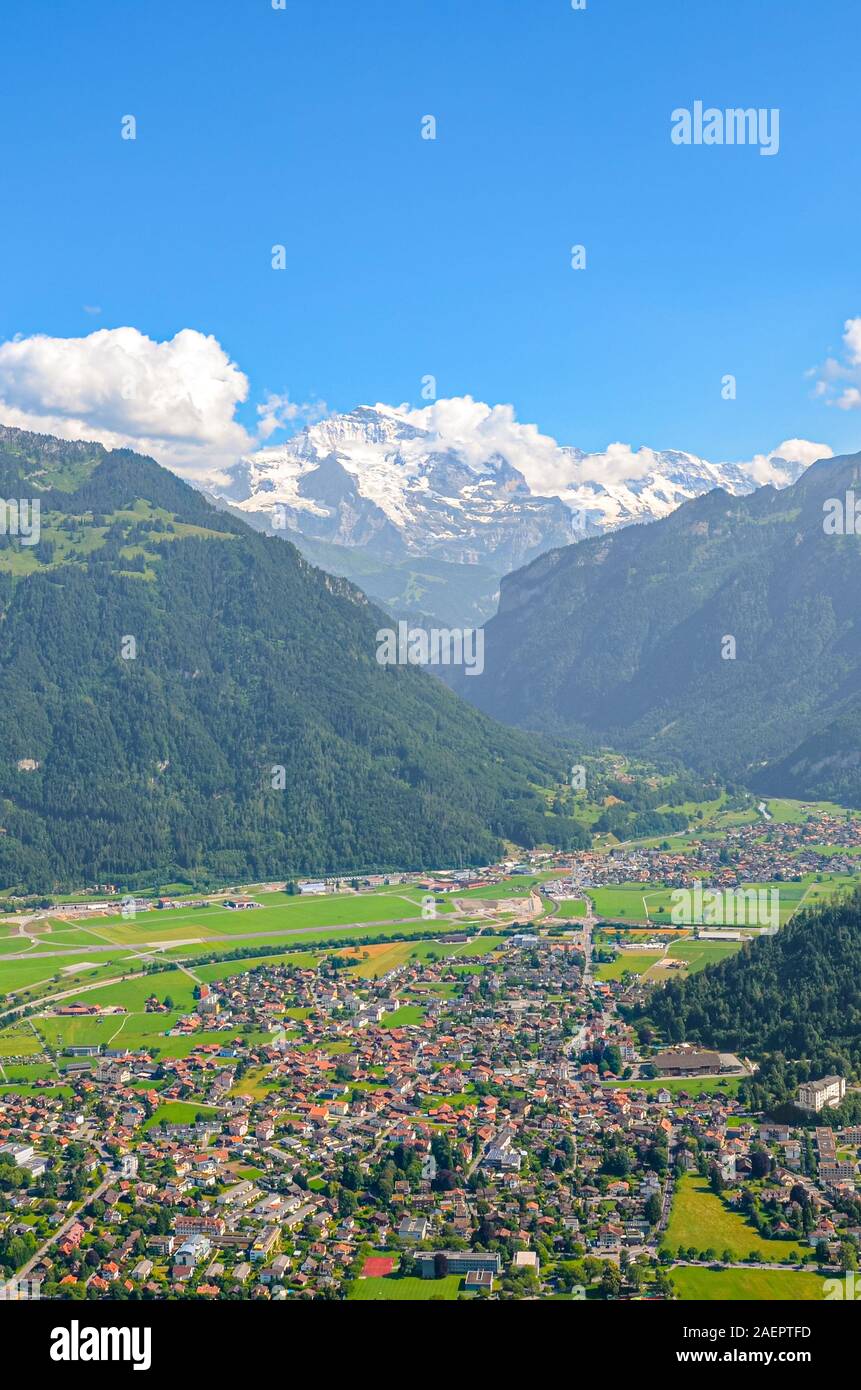Vista stupefacente di Interlaken e montagne adiacenti fotografata dalla cima di Harder Kulm in Svizzera. Alpi svizzere paesaggio. Città nella valle alpina circondata da montagne. Foto verticale. Foto Stock