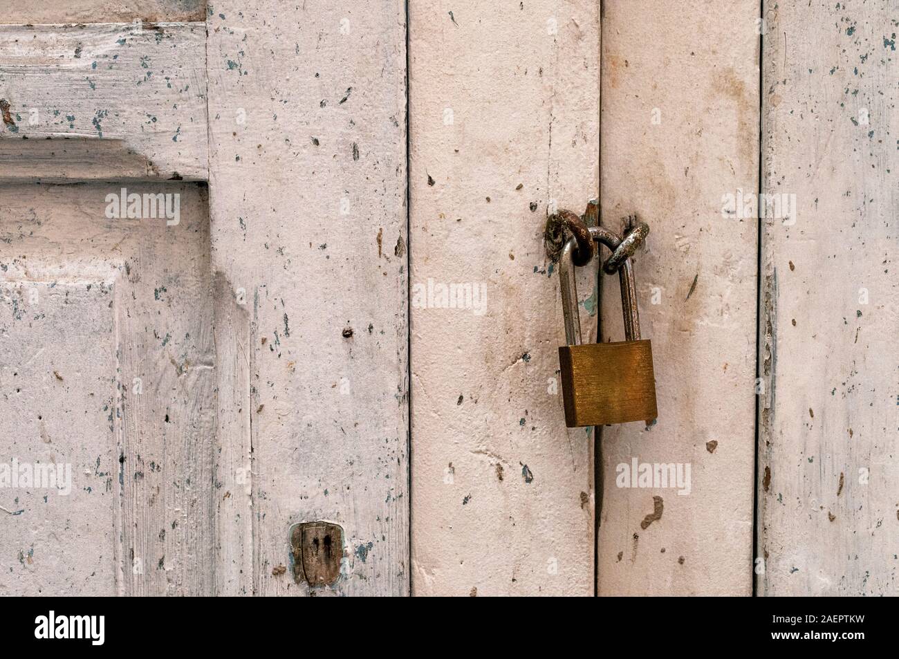 Il vecchio blocco di metallo su un bianco porta in legno Foto Stock