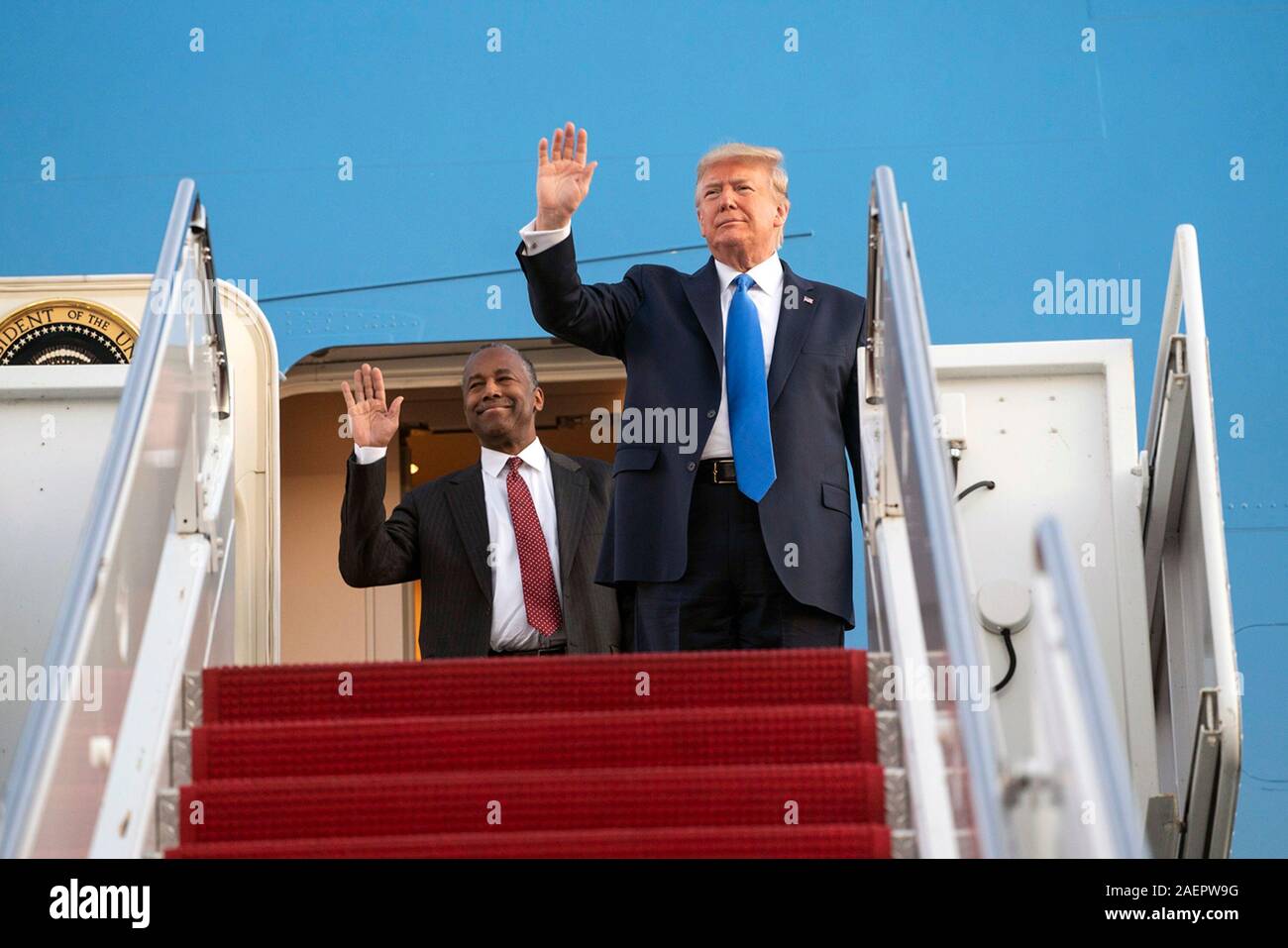 U.S presidente Donald Trump, uniti dal Segretario di Albergare e Sviluppo Urbano Ben Carson, onda per sostenitori come essi sbarcherà Air Force One a Fort Lauderdale-Hollywood Aeroporto Internazionale Dicembre 7, 2019 a Fort Lauderdale, Florida. Trump è in Florida a parlare all'israeliano Consiglio Americano vertice nazionale incontro presso il Diplomat Beach Resort. Foto Stock