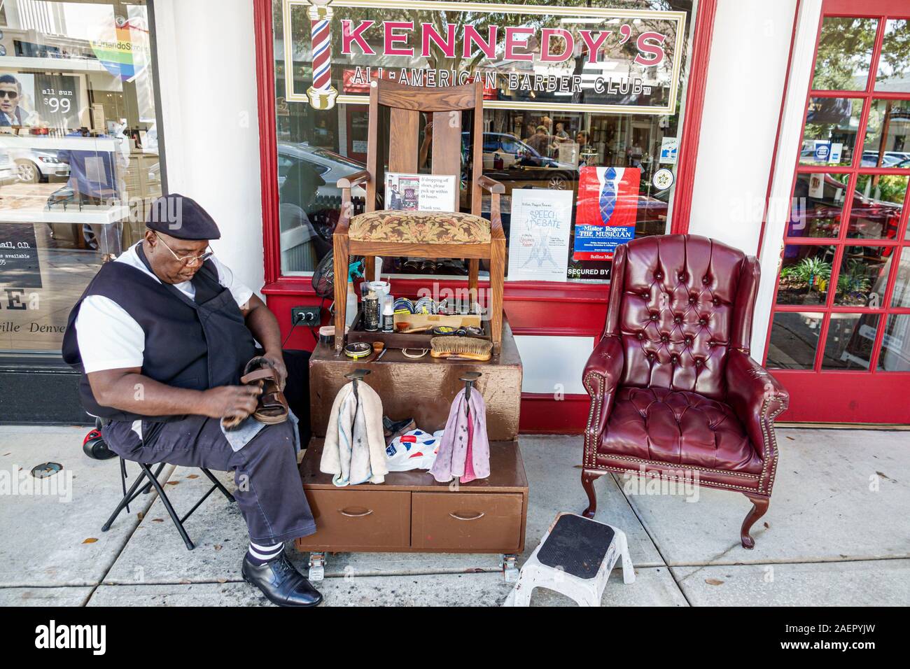 Orlando Winter Park Florida,Downtown,Park Avenue,quartiere dello shopping,Servizio Shine Shine Herman Baker's, shiner scarpe,lucidatrice scarponi,Black,man,working,sidew Foto Stock