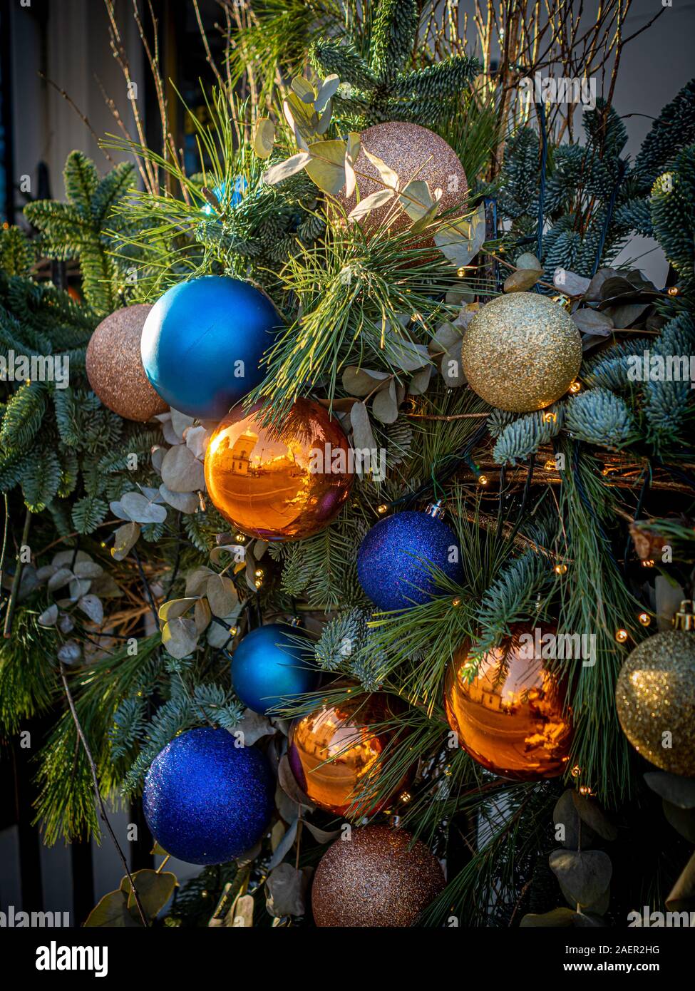 Ravvicinata di una ghirlanda di Natale con arancio e blu baubles, Belgravia, Londra, Regno Unito. Foto Stock